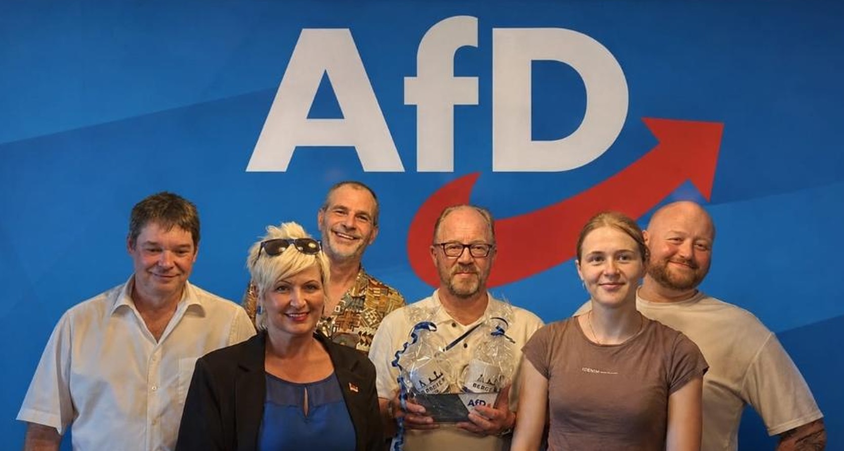 Der Vorstand des AfD-Stadtverbands Bergkamen vor dem AfD-Logo